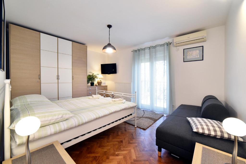a bedroom with a bed and a couch in it at Apartman Nola in Zagreb