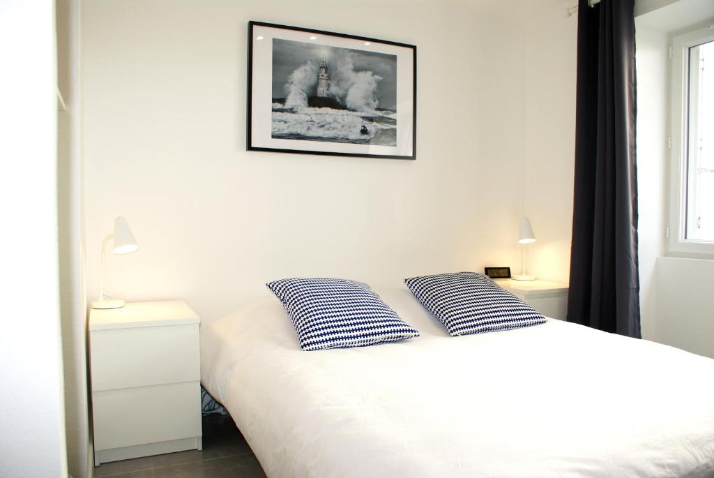 - une chambre avec un lit et 2 oreillers bleus et blancs dans l'établissement Studios meublés Brest Saint Marc, à Brest