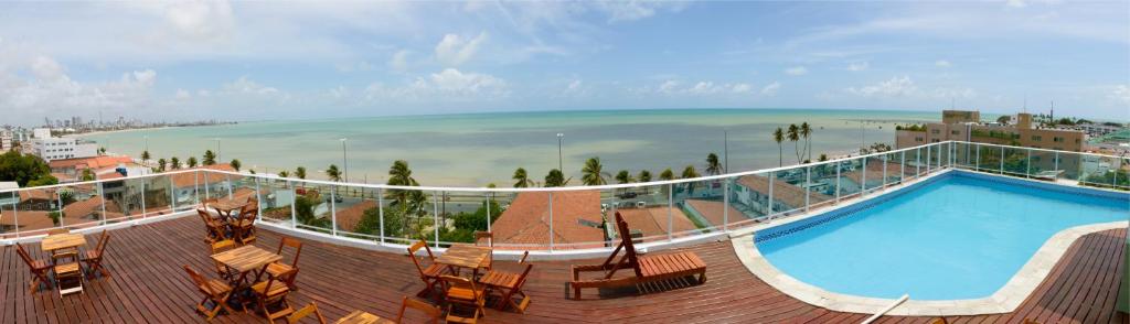 a swimming pool on a balcony with a view of the beach at Anjos Praia Hotel in João Pessoa