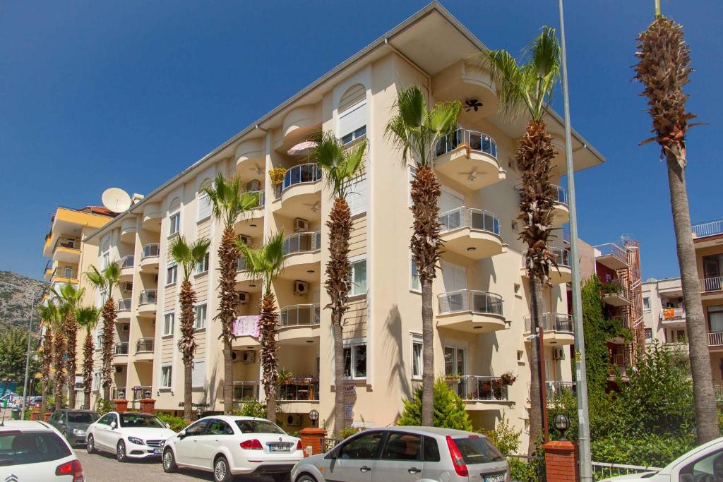 um edifício com palmeiras em frente em Emniyet Sokak Apartment em Alanya