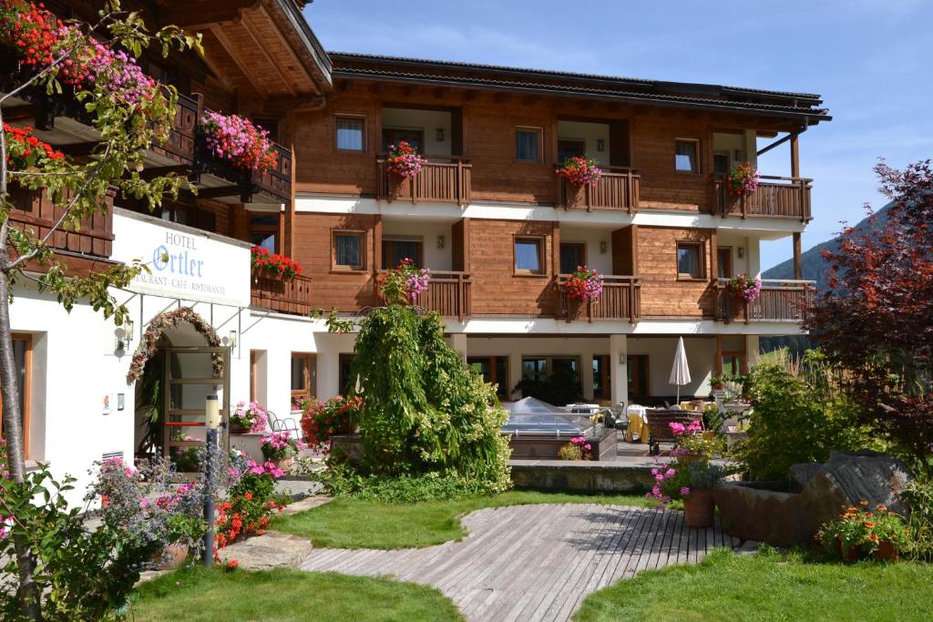 un hotel con flores frente a un edificio en Hotel Ortler, en Ultimo