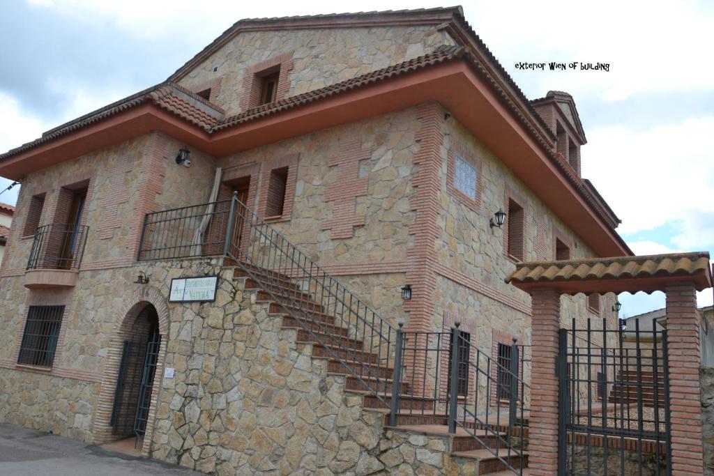 un edificio de piedra con escaleras en su lateral en Apartamentos Rurales Natura, en Torrejón el Rubio