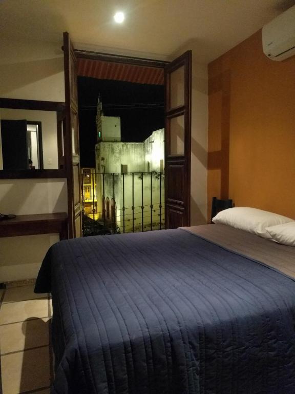 Un dormitorio con una cama grande y una ventana en Posada " El Jardín", en Xilitla