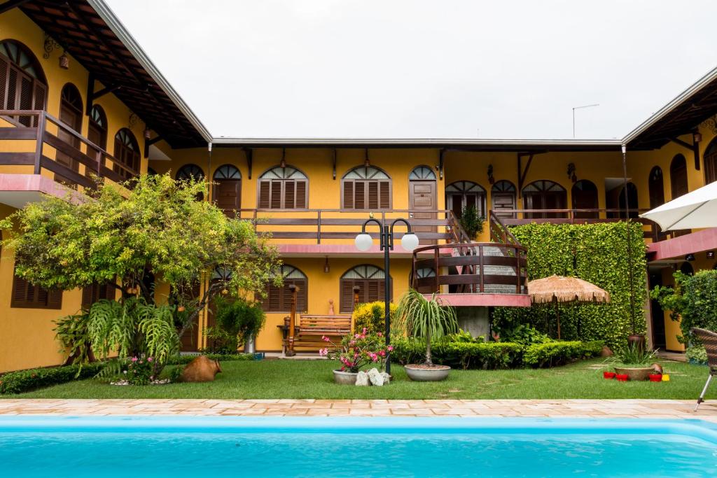 una casa con piscina frente a ella en Pousada da Terra en Natal