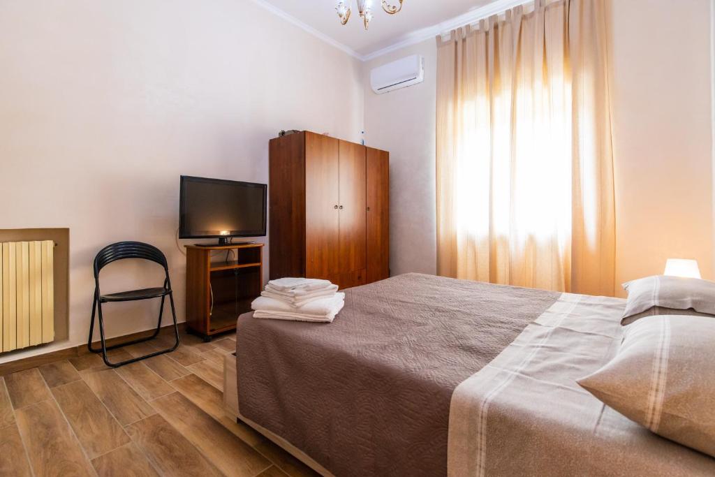 una camera con letto, TV e sedia di Casa di Annarella a Napoli