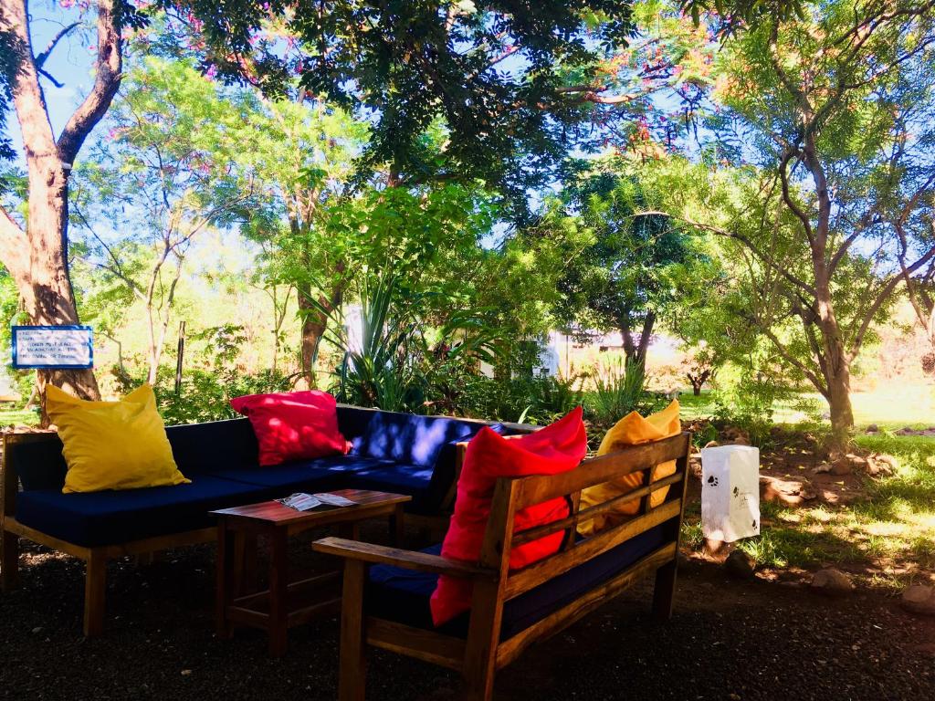 niebieska kanapa z kolorowymi poduszkami siedzącymi obok stołu w obiekcie Kamunjila Lodge w mieście Livingstone