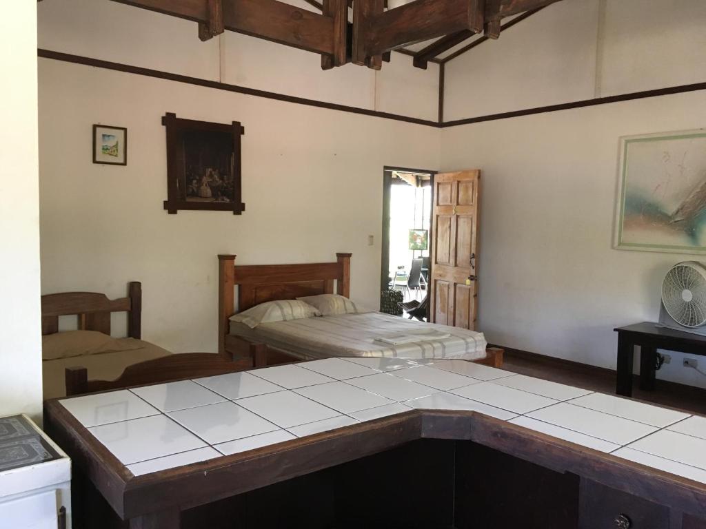 ein Wohnzimmer mit 2 Betten und einem Tisch in der Unterkunft Tiquisia Lodge in Curubandé