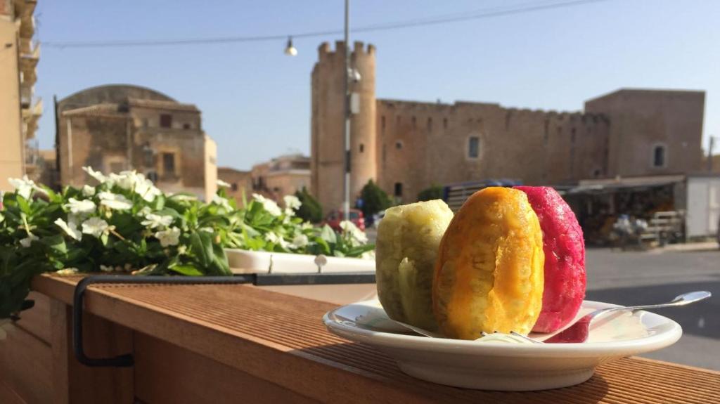 dois pedaços de fruta num prato numa mesa em Agli Antichi Quartieri Apartments em Alcamo