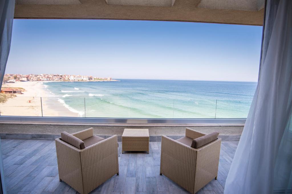 a room with two chairs and a view of the ocean at Villa Lili in Sozopol