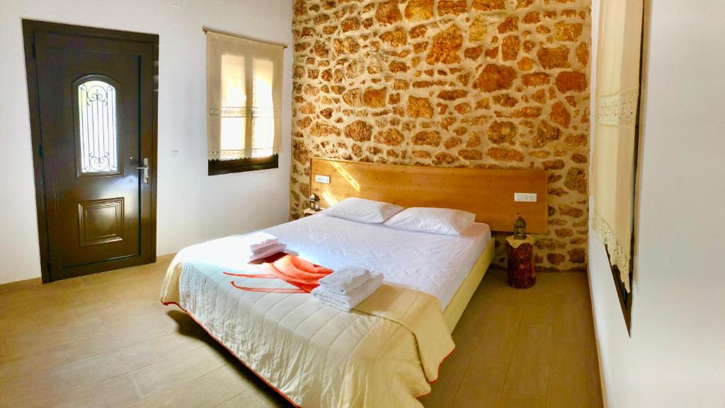 a bedroom with a bed and a brick wall at Bekos traditional house in Archangelos