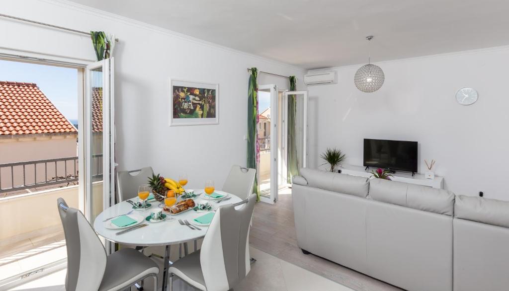 een witte woonkamer met een witte tafel en stoelen bij Apartment Pavlović in Dubrovnik