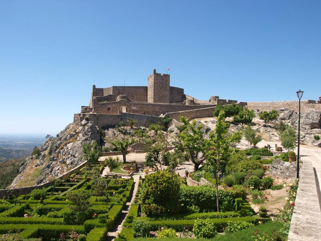 um castelo no topo de uma montanha com um jardim em El-Rei Dom Manuel Hotel em Marvão