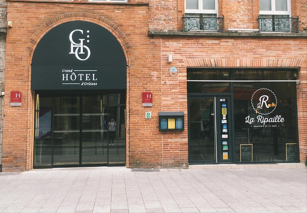 un edificio de ladrillo con dos entradas a un hotel en Grand Hôtel d'Orléans en Toulouse