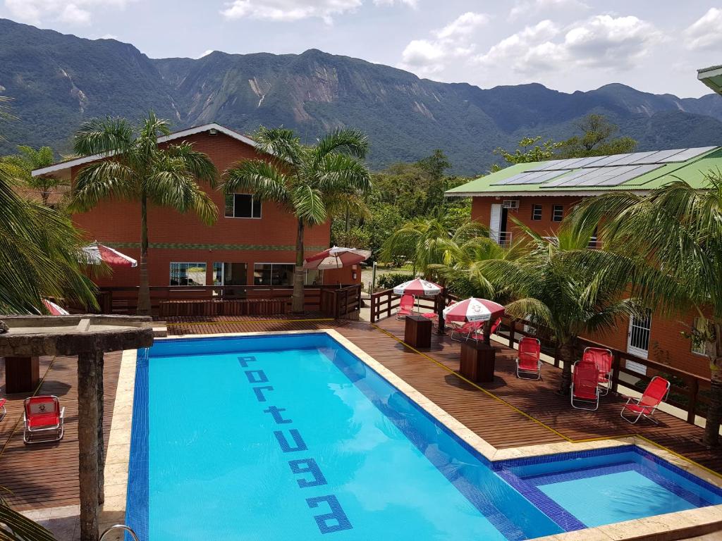 a pool at a resort with mountains in the background at Residencial dos Portugas in Boracéia