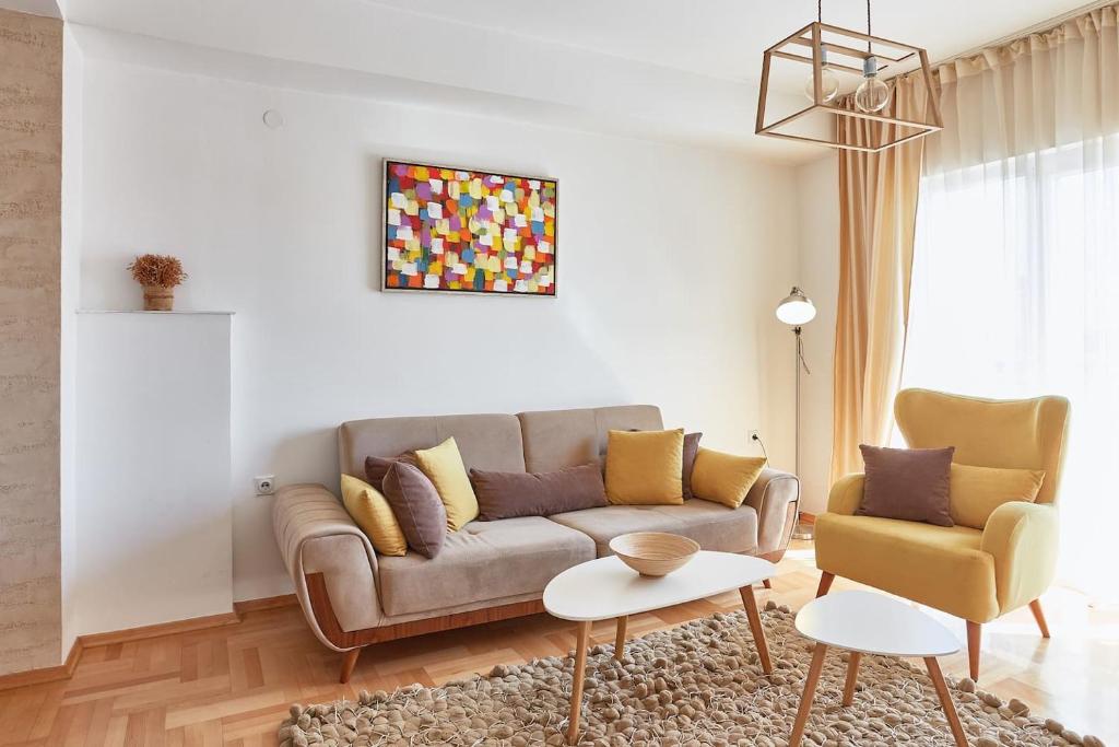 een woonkamer met een bank en een tafel bij Smart Apartments in Skopje