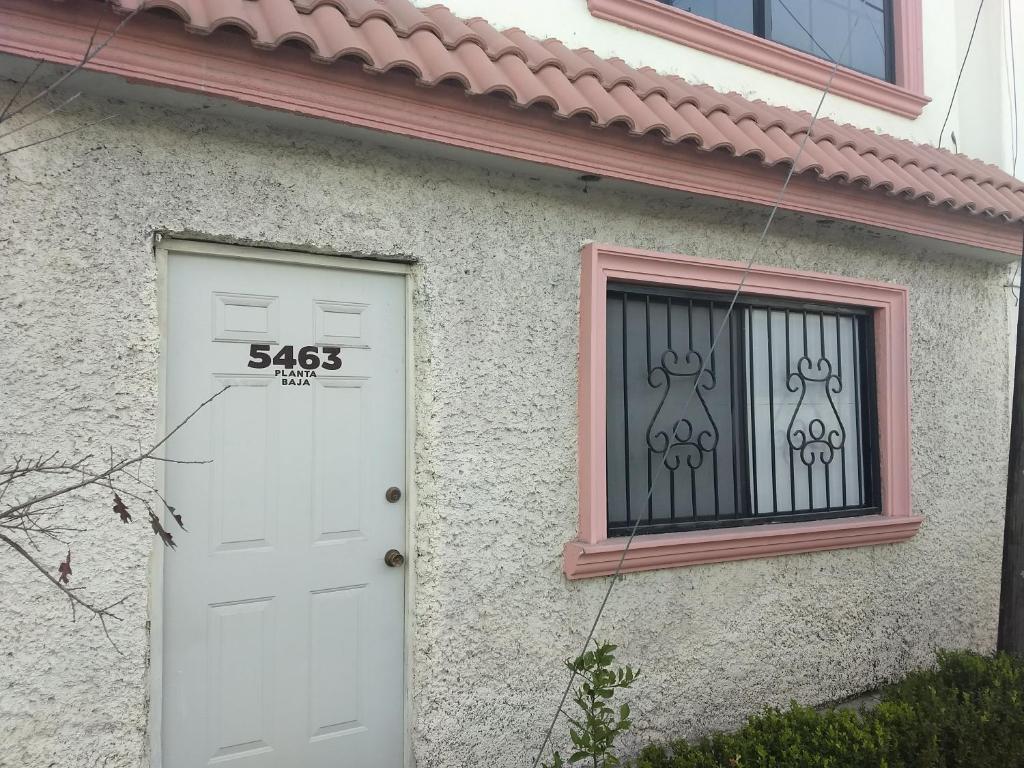 una casa con una puerta blanca y una ventana en Brisas 54634 en Monterrey