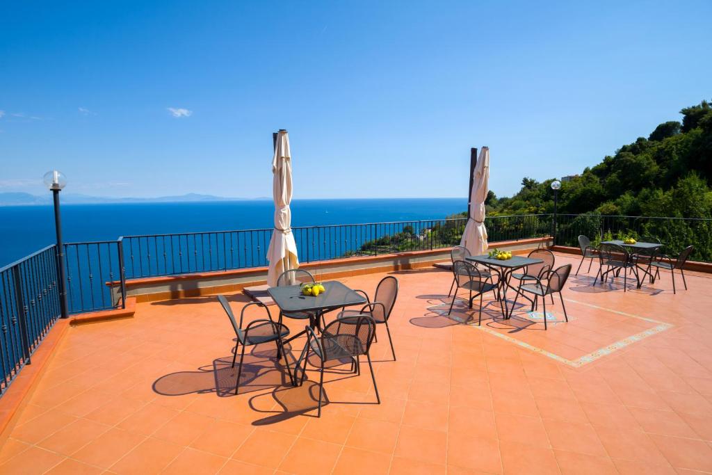 a group of tables and chairs on a balcony with the ocean at Il Glicine in Cetara