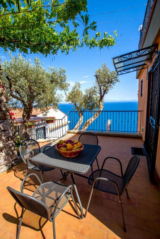 a table and chairs on a patio with a bowl of fruit at Il Glicine in Cetara