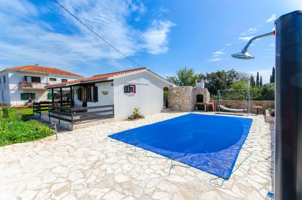 a villa with a blue pool in front of a house at House Ara in Grohote