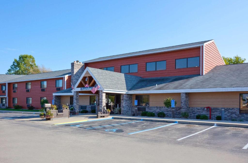 a hotel with a parking lot in front of it at AmericInn by Wyndham Menominee in Menominee