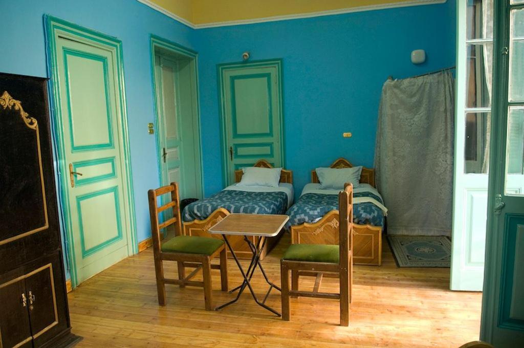 um quarto com uma cama, uma mesa e cadeiras em Berlin Hotel no Cairo