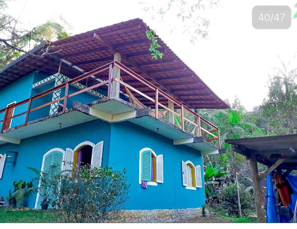 a blue house with a balcony on top of it at Suítes Doce Lar in Paraty