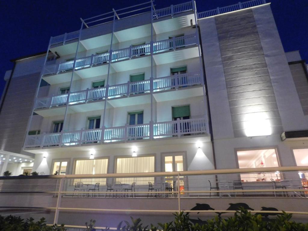a large white building with balconies and tables at Hotel Oceano in Marina di Pietrasanta