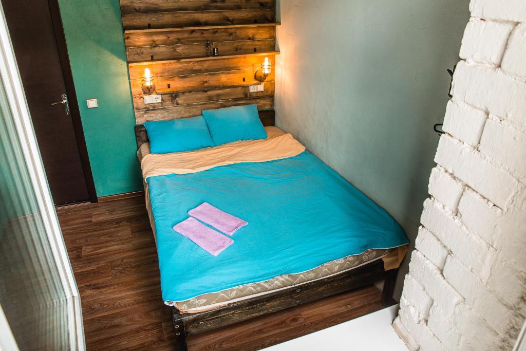 a small bed with blue sheets and blue pillows at Montana hostel in Irkutsk