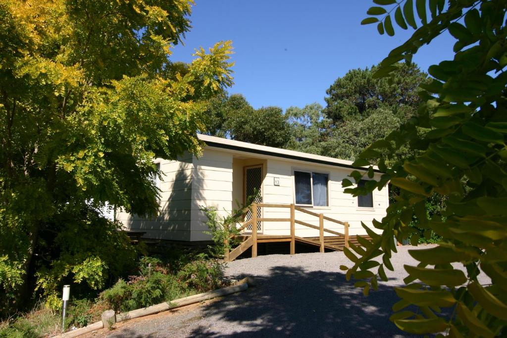 a small white cottage with a porch at Millicent Hillview Caravan Park in Millicent