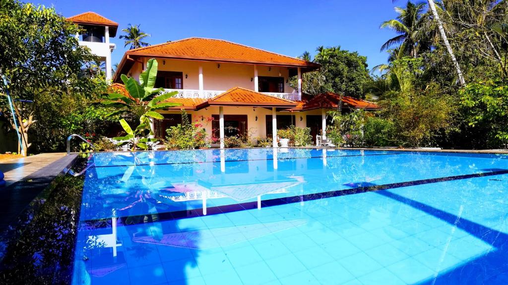 a large swimming pool in front of a house at Siroma Villa in Bentota