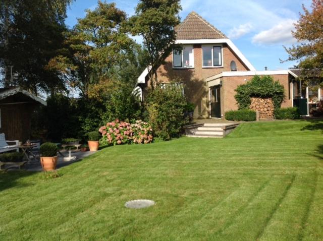 a house with a yard with a frisbee in the grass at Wide ie Grou in Nes