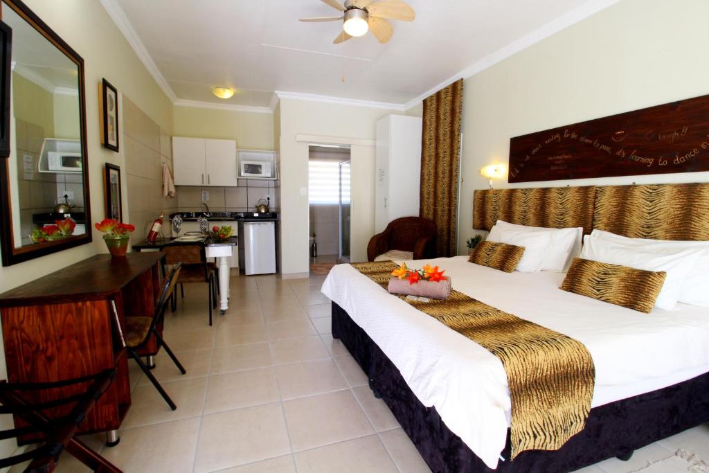 a hotel room with a bed and a kitchen at Wilger Guesthouse in Centurion