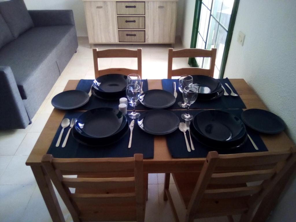 uma mesa com pratos pretos e óculos em Caleta Paraiso - Lovely Coastal Apartment em Costa de Antigua
