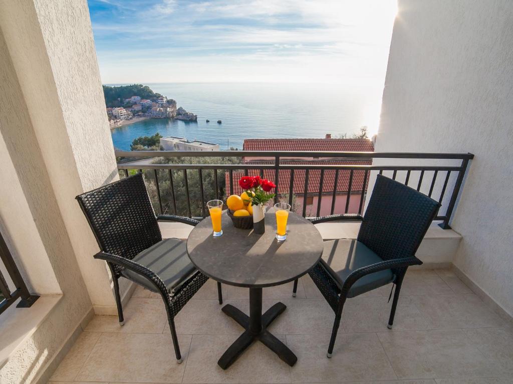 d'une table et de chaises sur un balcon avec vue sur l'océan. dans l'établissement Villa Mona 2, à Budva