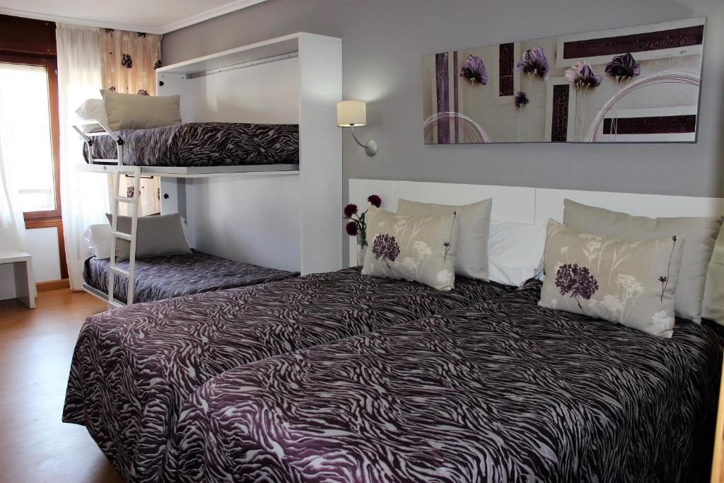 a bedroom with a bed and a bunk bed at Hotel Las Olas in Noja