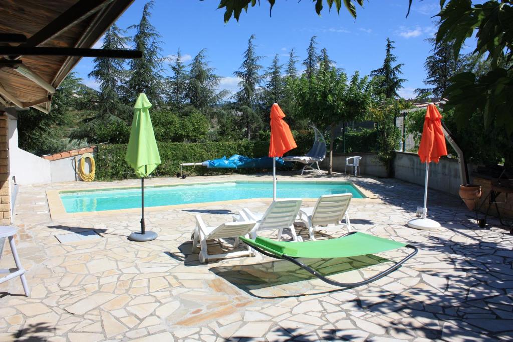 - une piscine avec 2 chaises longues et des parasols dans l'établissement Domaine de Charoussas le mas de mon père, à Lagorce