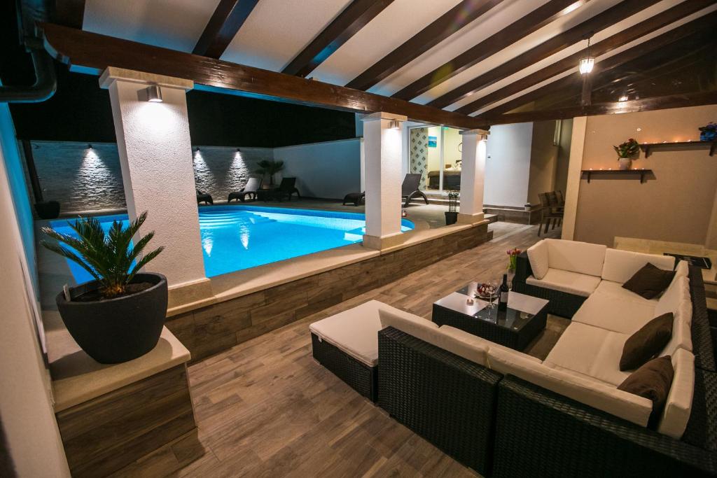 a living room with a couch and a swimming pool at Luxury apartment Elis with private pool in Pula