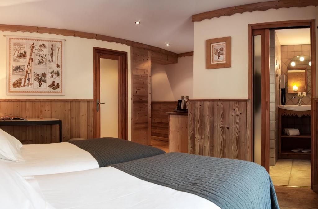 a hotel room with a bed and a bathroom at Auberge du Manoir in Chamonix