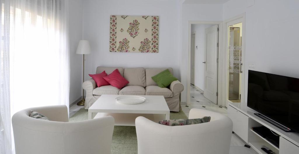 a living room with a couch and a table and chairs at Entre Magnolios in Córdoba