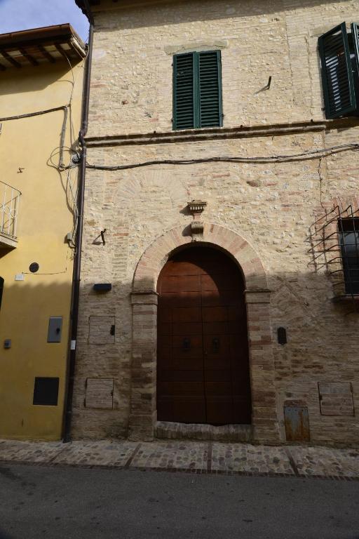 a brick building with a brown door on it at B&B FEDERICO II in Montefalco