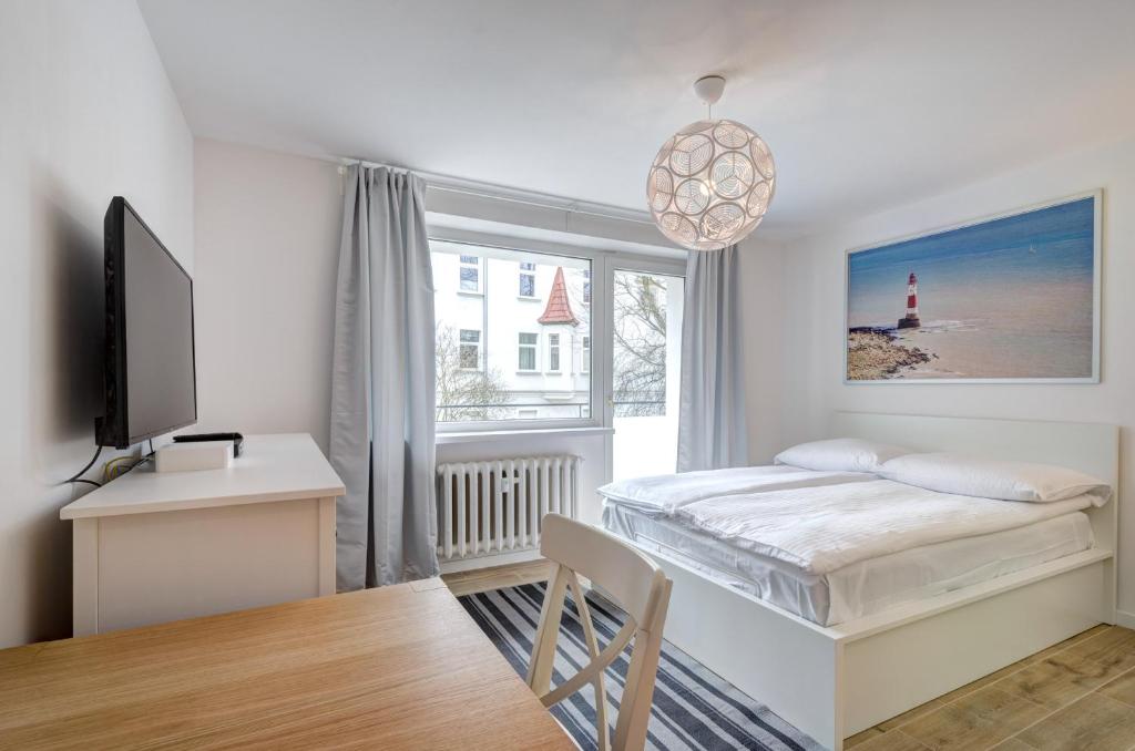 a bedroom with a bed and a tv and a window at DR Apartments - Five in Sopot