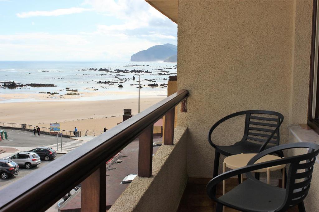 a balcony with chairs and a view of a beach at Hotel Las Olas in Noja