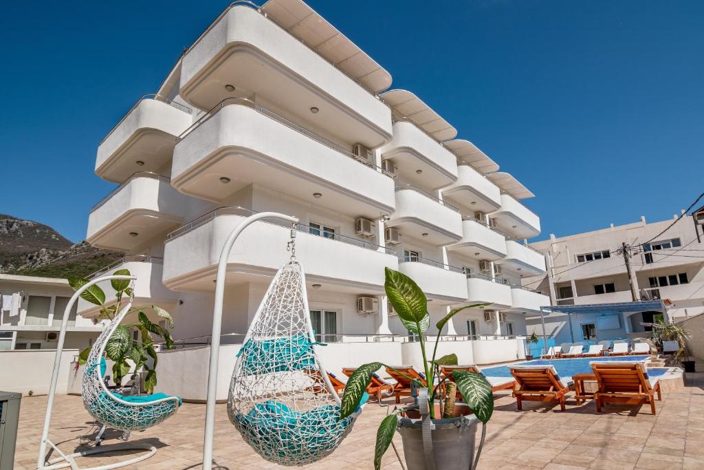 a large building with two hanging hammocks in front of it at Bianca Apartments in Herceg-Novi