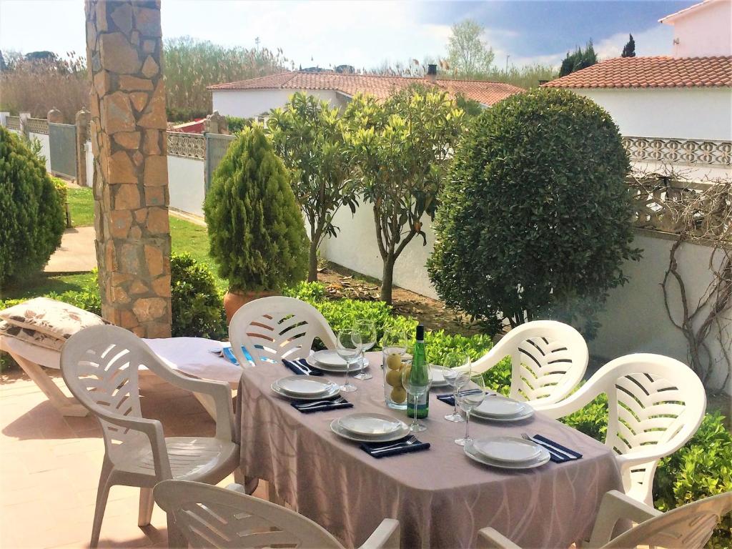 un tavolo con sedie bianche e una tovaglia da tavolo su un patio di Villa Montserrat 1, Terrace & Pool a Sant Martí d'Empúries