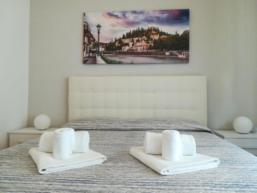 1 dormitorio con 1 cama y 2 toallas blancas en A casa di Luca, en Verona