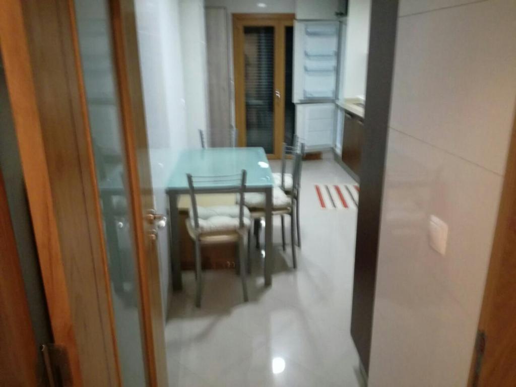 een eettafel en stoelen in een kamer bij ADALBERTO NASCIMENTO LUXURY APARTA-HOSTEL At COLINAS DO CRUZEIRO in Odivelas