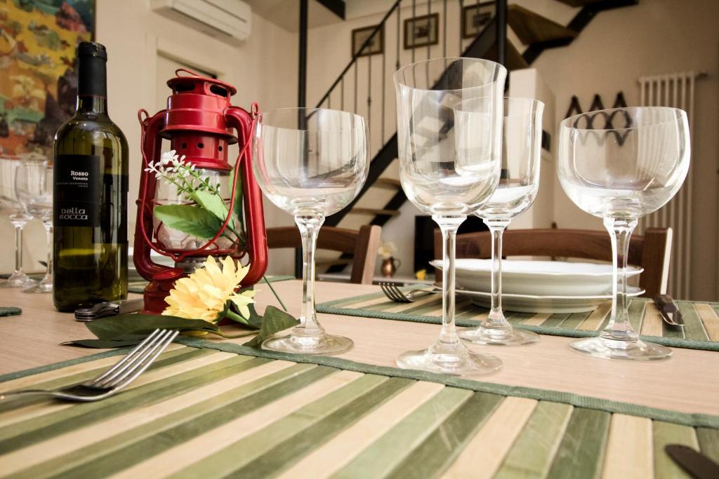 einen Tisch mit Weingläsern und eine Flasche Wein in der Unterkunft La Torre Holiday House in Pisa