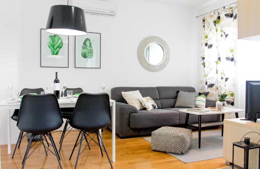 Serena Apartment في بودسترانا: غرفة معيشة مع أريكة وطاولة وكراسي