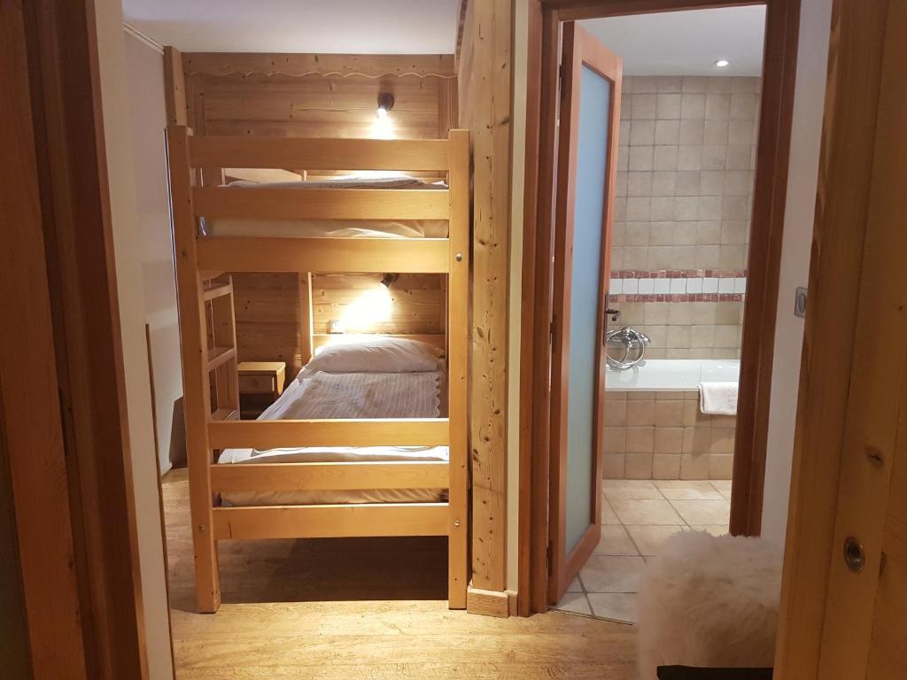 a room with a bunk bed and a bathroom at Auberge du Manoir in Chamonix