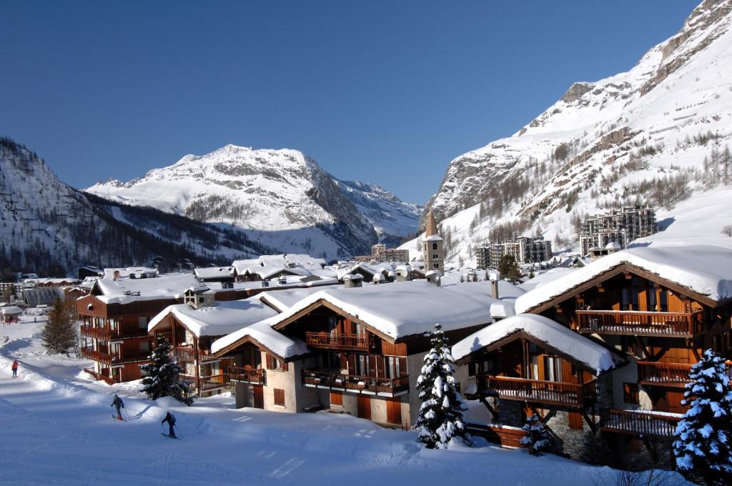 a ski lodge in the mountains with snow covered roofs at Résidence Odalys Les Hauts du Rogoney in Val dʼIsère
